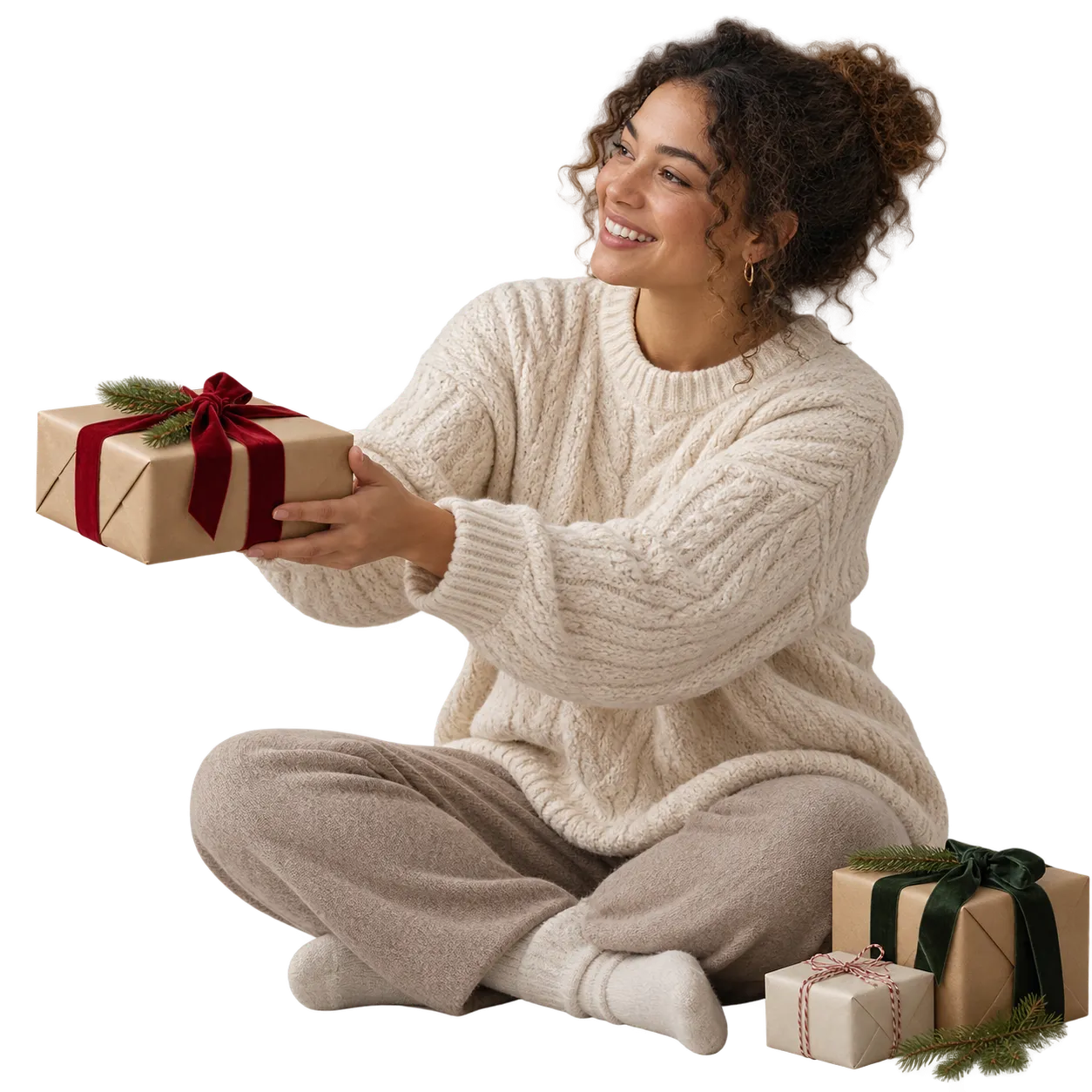A person offering a wrapped Christmas present beside a softly lit tree.
